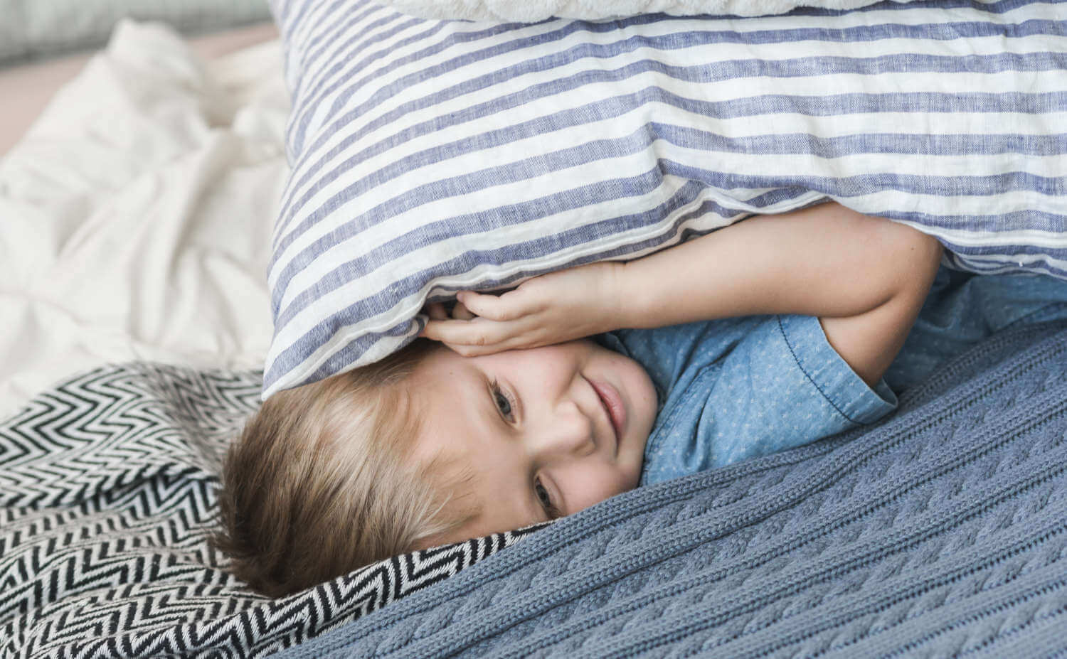 two-pillows-smiling-little-boy-lying-bed.jpg